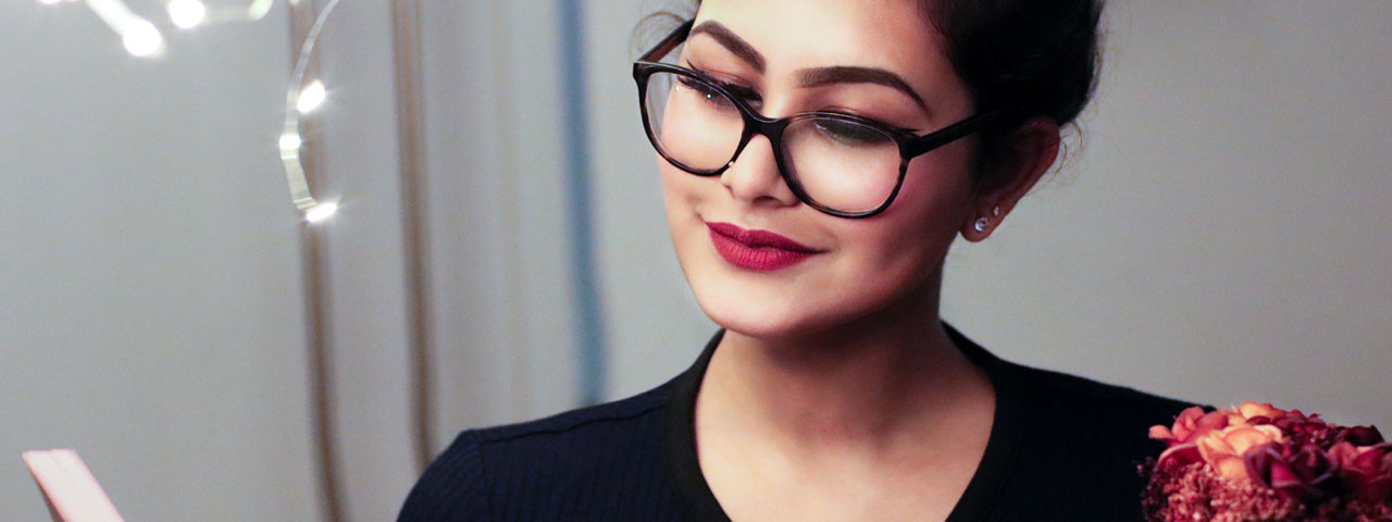woman wearing glasses reading before an eye doctor's appointment